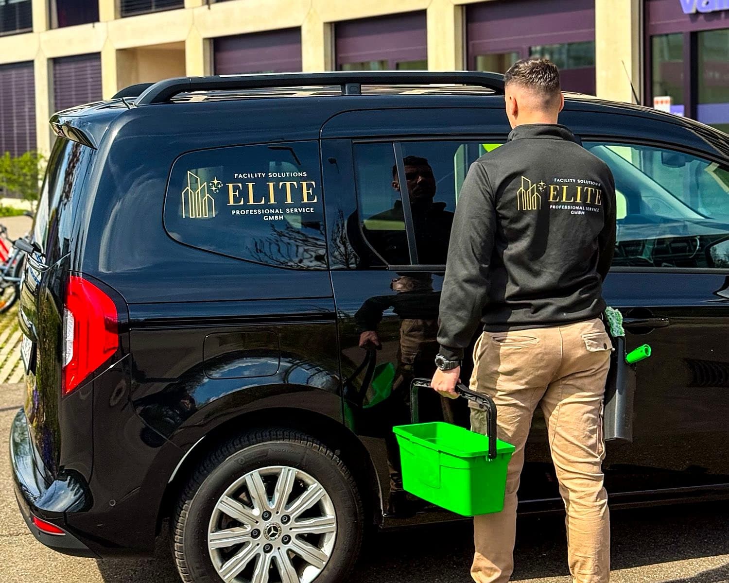 Mitarbeiter mit Reinigungsausrüstung am Firmenfahrzeug von Elite Professional Service
